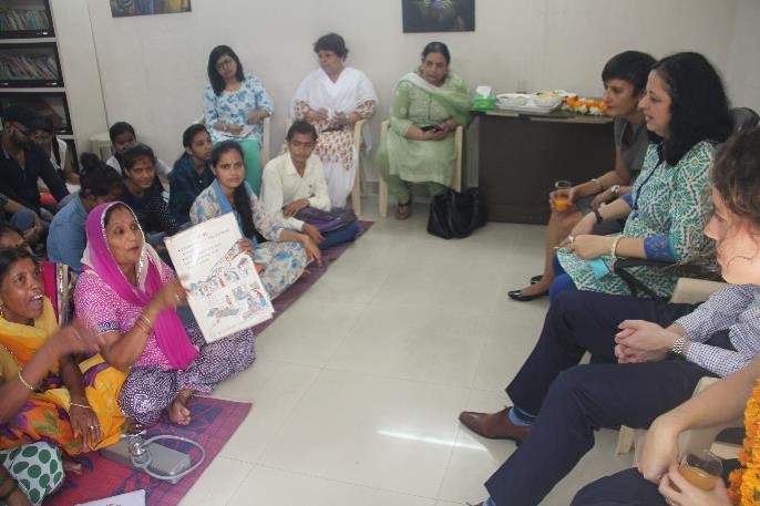 Asha Community Health Volunteer explains the flashcard to Ms Sidhu.